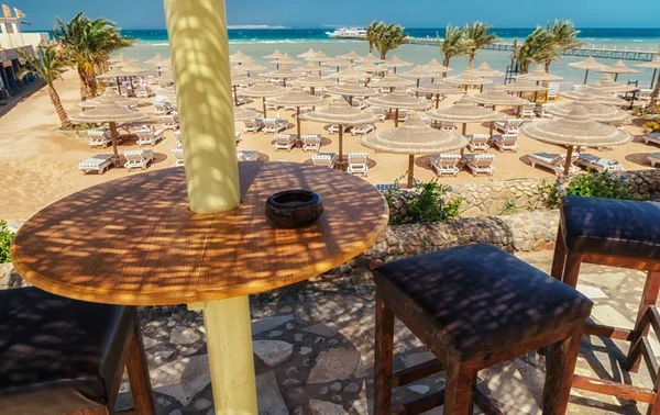 Liegestühle und Sonnenschirme am Strand gegen den blauen Himmel und — Stockfoto