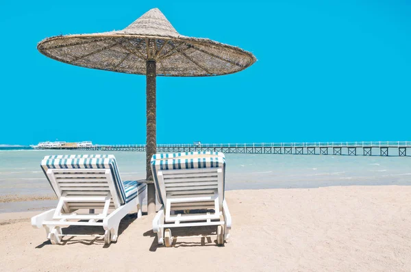 Salon de chaise et parasols sur la plage contre le ciel bleu et — Photo