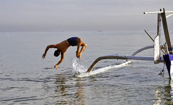 一名男子从传统的巴厘岛船跳 — 图库照片