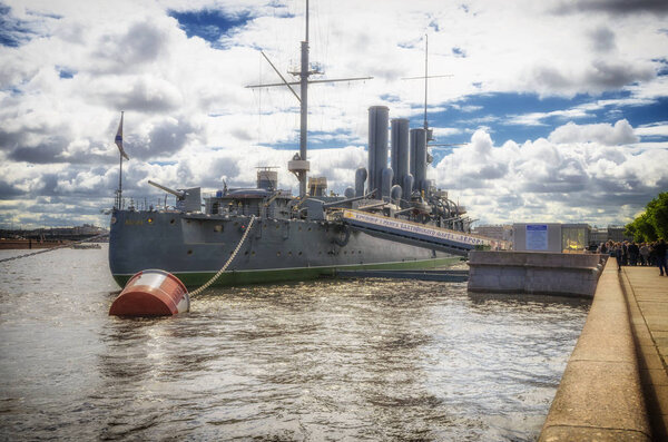 JUNE 28, 2017: Cruiser Aurora on her mooring place in front of the Nakhimov College in St. Petersburg
