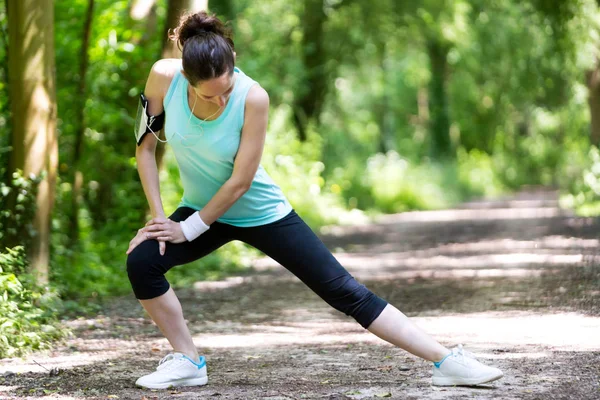 Mujer estirándose después de correr —  Fotos de Stock