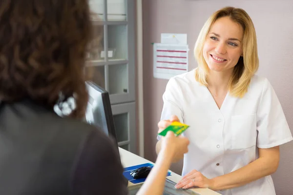 Esteticista feliz obter cartão de crédito — Fotografia de Stock