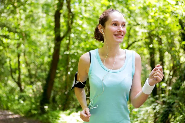 Jonge vrouw rennend in bos — Stockfoto