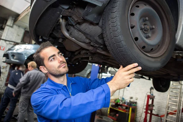 Mechanic working on a car at the garage — Stock Photo, Image