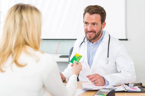 Unga attraktiva läkare lyssnar hans patient — Stockfoto