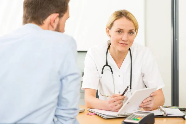 Young attractive doctor listening his patient — Stock Photo, Image