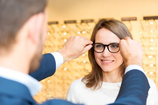 Mulher testando novos óculos com óptico — Fotografia de Stock