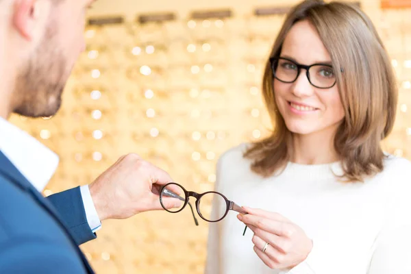 Mujer probando nuevas gafas con óptico —  Fotos de Stock