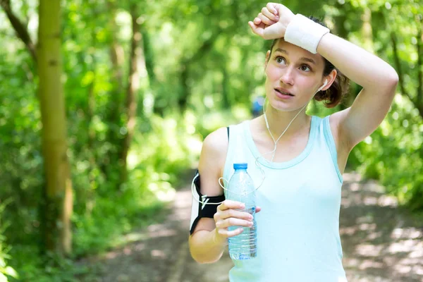 Mujer bebiendo agua después de una sesión de running —  Fotos de Stock