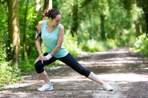 Frau dehnt sich nach einer Laufeinheit — Stockfoto