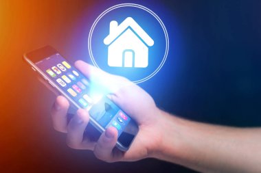 Hareket eden telefon ile ev simgesini tutan işadamı el 