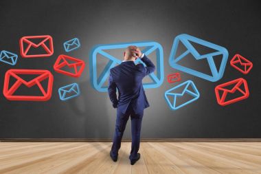 İşadamı onaylı e-posta ve spam karışıklık ile bir duvar önünde