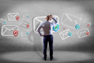 İşadamı onaylı e-posta ve spam karışıklık ile bir duvar önünde