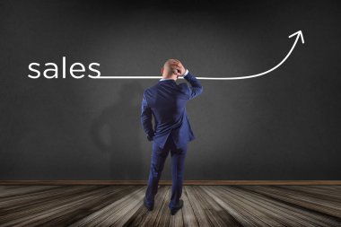 işadamı bir duvarın önünde 