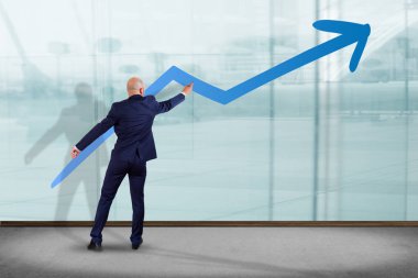 İşadamı büyüyen bir iş ok çizim bir duvarın önünde