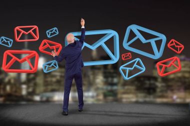 İşadamı onaylı e-posta ve spam karışıklık ile bir duvar önünde