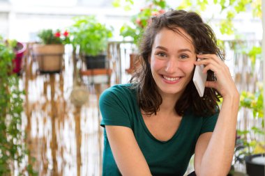 Onun şehir Bahçe balkonda onu smartphone kullanan genç kadın 