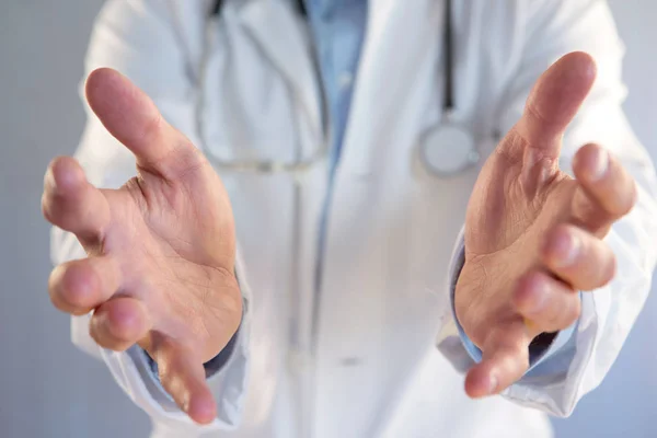 Arzt gibt leere Hand auf farbigem Hintergrund — Stockfoto