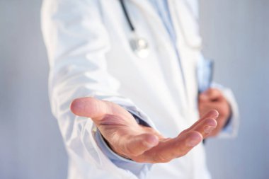 Bir renk arka plan üzerinde boş bir el veren doktor