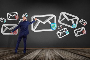 İşadamı onaylı e-posta ve spam karışıklık ile bir duvar önünde