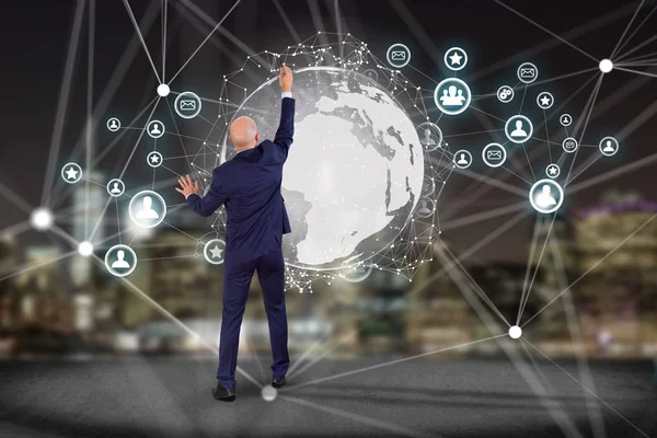 Geschäftsmann vor einer Wand mit internationaler Netzwerkanzeige — Stockfoto