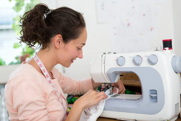 Jovem mulher costureira usando máquina de costura — Fotografia de Stock