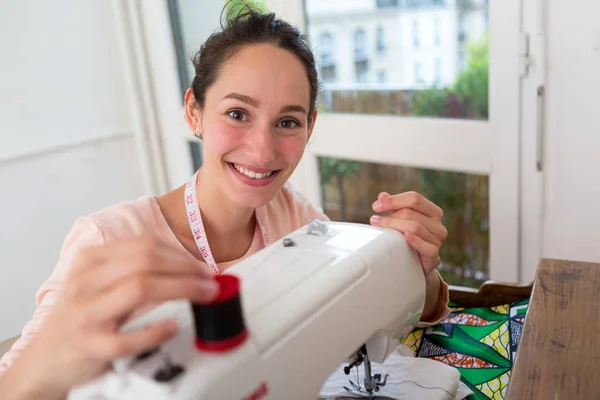 Женщина устанавливает свою швейную машинку — стоковое фото