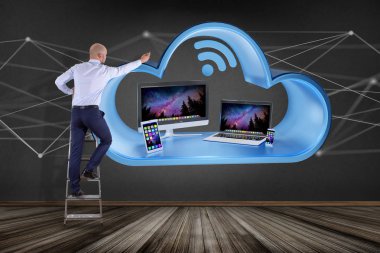 İşadamı aygıt ile bir duvar önünde