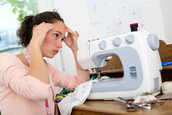 Mulher com dificuldades com máquina de costura — Fotografia de Stock