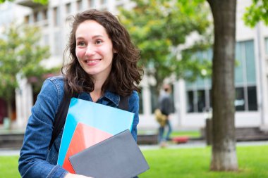 Genç öğrenci okula gidiyor ve defter tutan sırt çantası ile
