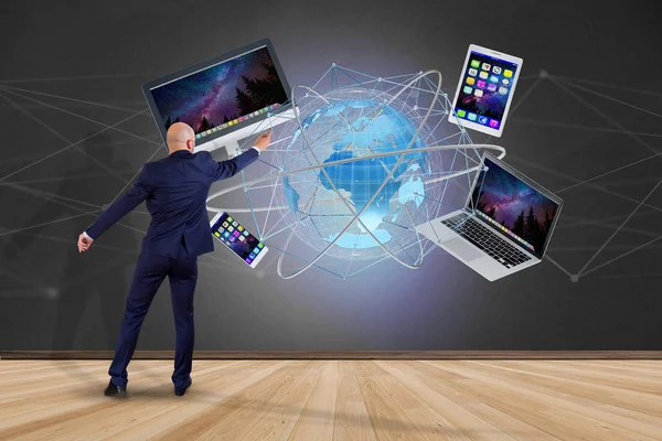 一个商人在墙前的看法与计算机和设备显示在未来的界面与国际网络 — 图库照片