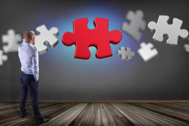 Puzzle parçaları ile bir duvar önünde bir işadamı görünümünü