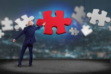 İşadamı görünümünü Puzzle parçaları ile duvar önünde