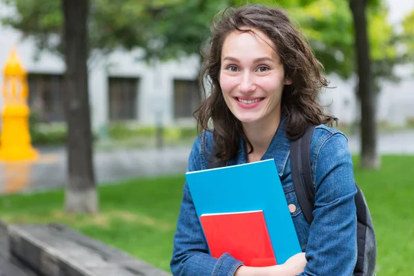 バックパックとノートを保持している若い学生の肖像画 — ストック写真