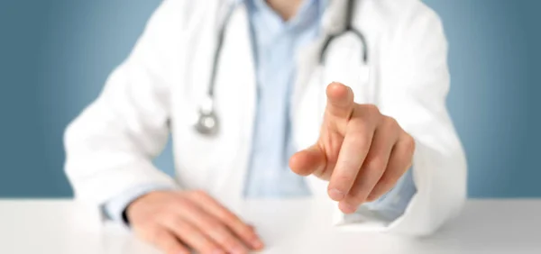 Arzt Zeigt Mit Dem Finger Auf Klinik Vor Blauem Hintergrund — Stockfoto