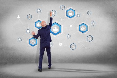 İşadamı teknoloji simgeleri fütüristik arabirim üstünde görüntülenen iş ağ bağlantısı ile duvar önünde