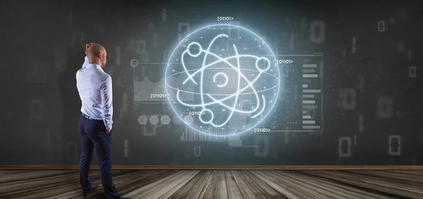Businessman holding an atom icon surrounded by data — Stock Photo, Image