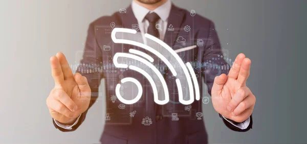 Geschäftsmann hält ein Wifi-Symbol mit Daten rundherum — Stockfoto