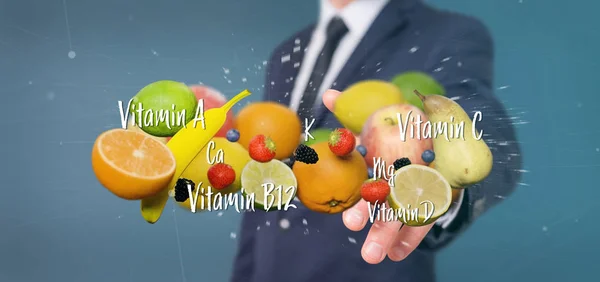 Affärsman som innehar frukter och vitaminer - 3d rendering Stockbild