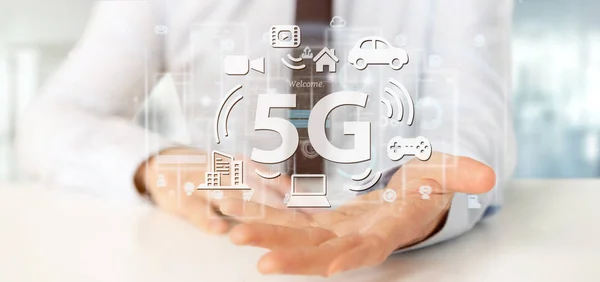 Empresario sosteniendo una conexión 5G con los datos que rodean - 3d r —  Fotos de Stock