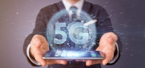 Empresario sosteniendo una conexión 5G con los datos que rodean - 3d r —  Fotos de Stock