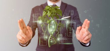 View of a Businessman holding a DNA growing as a plant - 3d rendering