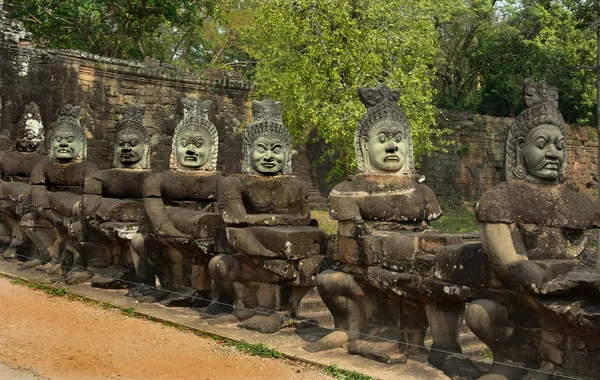 Row of sculptures in the South Gate of Angkor Thom complex. Siem Reap, Cambodia — Stock Photo, Image