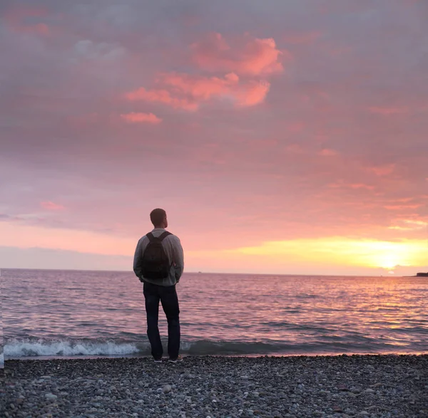 Egyedül az ember nézi a naplementét a strandon — Stock Fotó