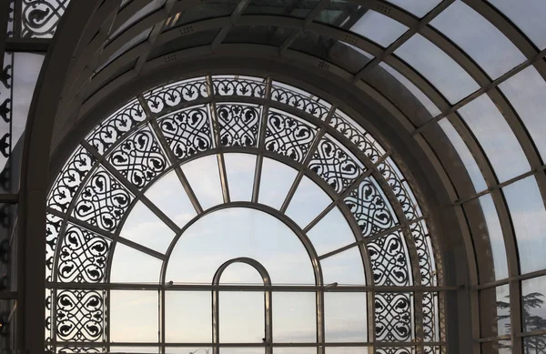 glass arch window with patterned metal elements