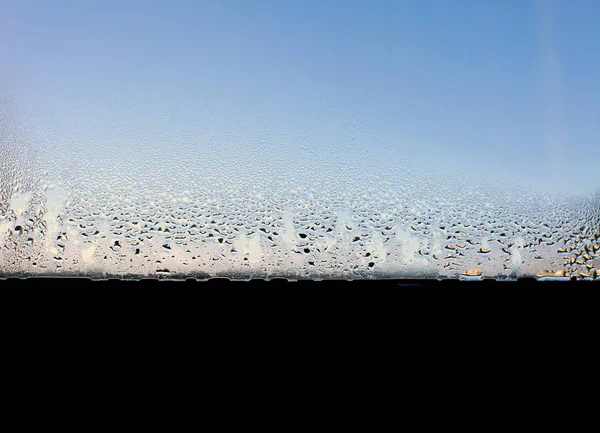 L'eau tombe sur le verre de la fenêtre humide. Contexte abstrait. — Photo