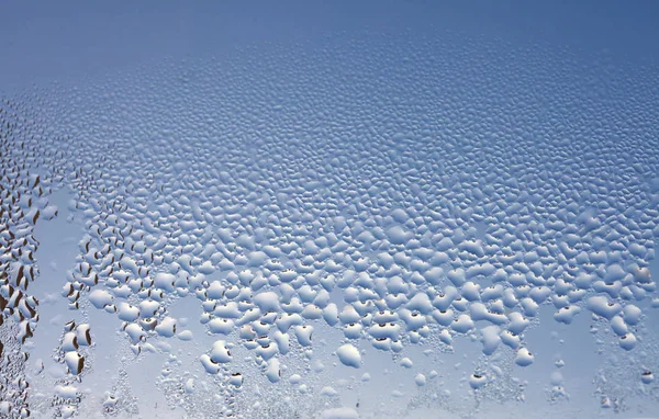 Water druppels op het natte raam glas. Abstracte achtergrond. Blauw c — Stockfoto