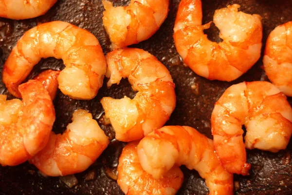 Fried Argentinean tiger prawns with garlic in olive oil in a pan