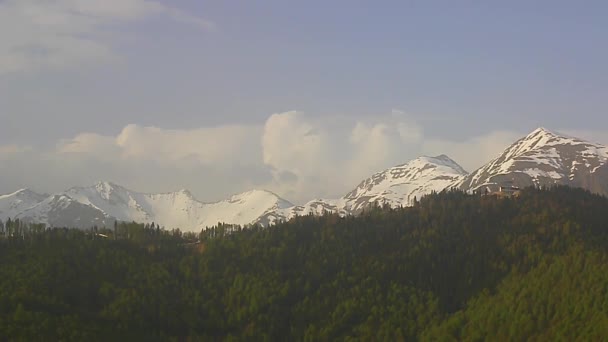 Forêts de montagne, cumulus et sommets enneigés du Caucase 