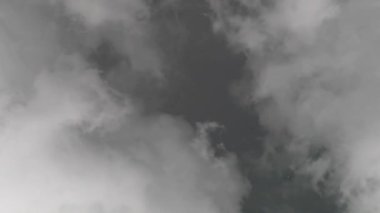 Gökyüzü yağmur beklentisiyle gri bulutlarla kaplıdır. Bulutlar hızlı hareket ediyor. Gri bulutlar arasında kara bulutlarla görülebilir bir boşluk var.